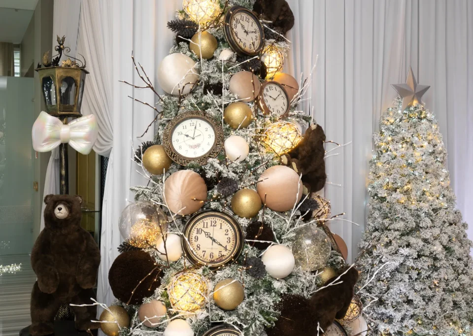 Árbol blanco nevado con relojes y esferas doradas