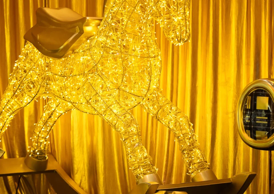 Caballito mecedor dorado iluminado con cascabeles gigantes