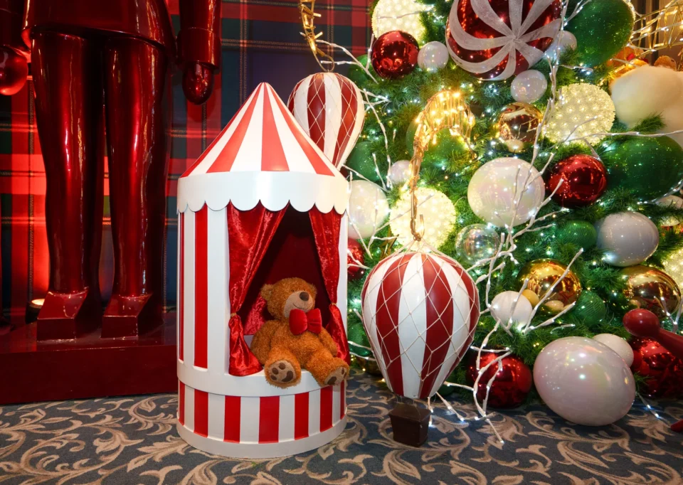 Carpa de circo roja con oso de peluche y globo aerostático