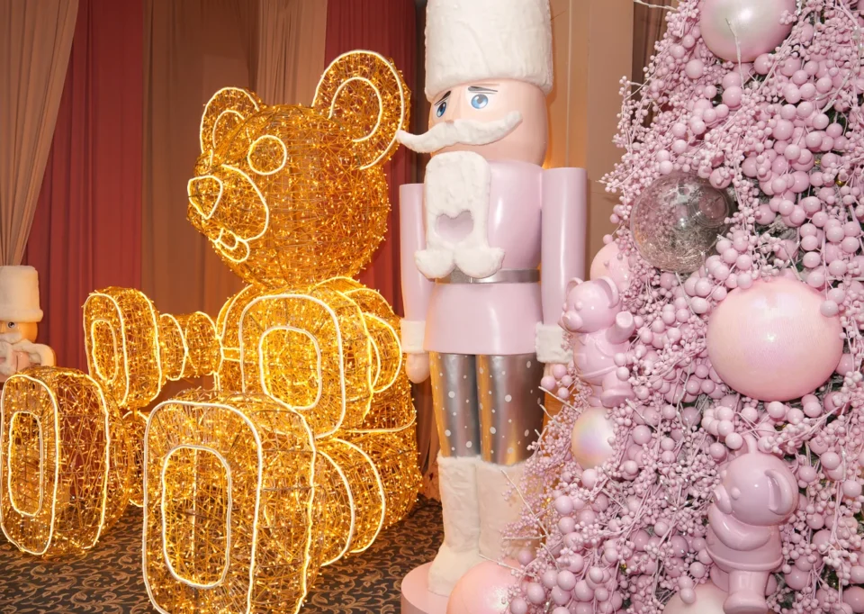 Cascanueces blanco y rosa junto a un oso iluminado y un árbol rosa