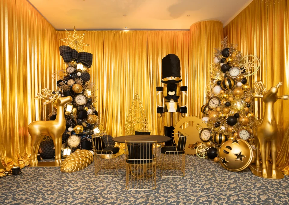 Sala dorada con árboles negro y oro, renos y cascanueces