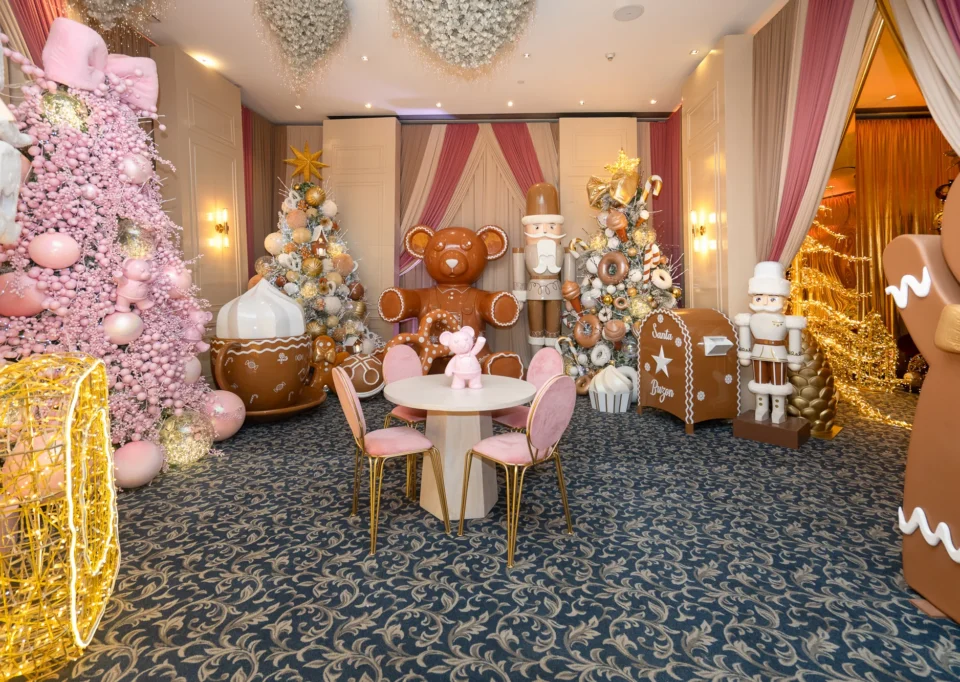 Sala rosa y dorada con árboles, oso gigante y mesas temáticas